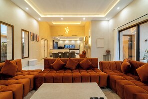 Ein modernes Wohnzimmer mit einer Eckcouch, einem Couchtisch und einem Fernseher im Hintergrund.