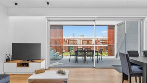 Ein modernes Wohnzimmer mit Flachbildfernseher, Couchtisch und Sofa.