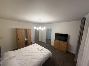 A bedroom with a bed, a TV, a wardrobe, and a mirror. - Spacious 2-Room Apartment near Brașov Center | Random Studio | Pet frendly (Brașov)
