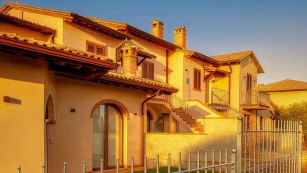 A two-story house with a well-maintained lawn, a metal fence, and a staircase leading to the upper floor. - Modern and cozy suite for couples and families "Calliope" (Vernazzano Basso)