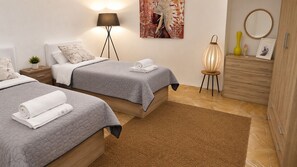 A bedroom with two beds, a nightstand, a lamp, a mirror, a dresser, and a rug. - Dragonfly Retreat Málaga | Private Villa & Rose Pool (Coín)