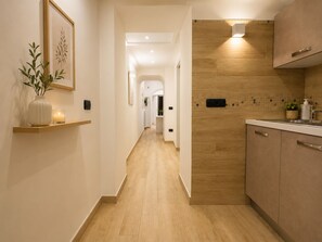 Eine moderne Küche mit Holzschränken, einer Arbeitsplatte und einer Wandleuchte.