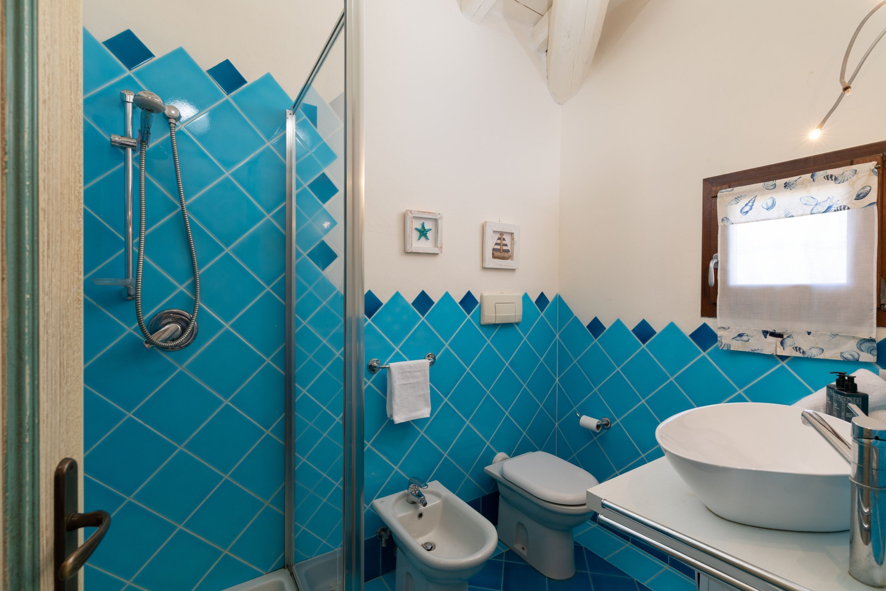 Un baño con ducha, bidé, inodoro y lavabo.