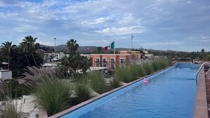 En swimmingpool med udsigt til bygninger og et flag.