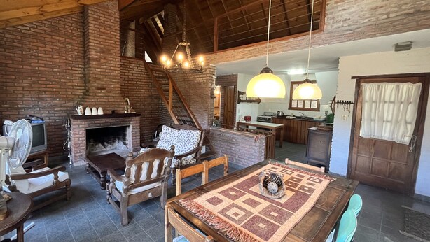 Un interior rústico con chimenea, muebles de madera y un comedor.