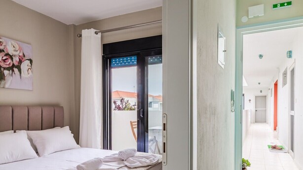 Habitació d'hotel amb llit, un quadre, bany amb dutxa i vista exterior.