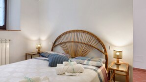A room with a bed, a window, an air conditioner, a bedside lamp, and a wall-mounted light. - Casa del Custode: Via degli Dei – Mugello Circuit (Tagliaferro)