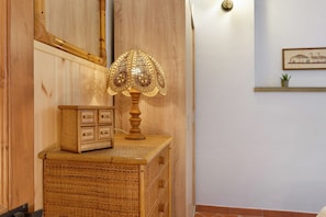 A wooden cabinet with a woven basket and a decorative lamp with a patterned lampshade.