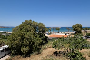 A coastal area with a beach, trees, and a parked RV. - Sun & Beach Apartment in Chania 14 (Chania)
