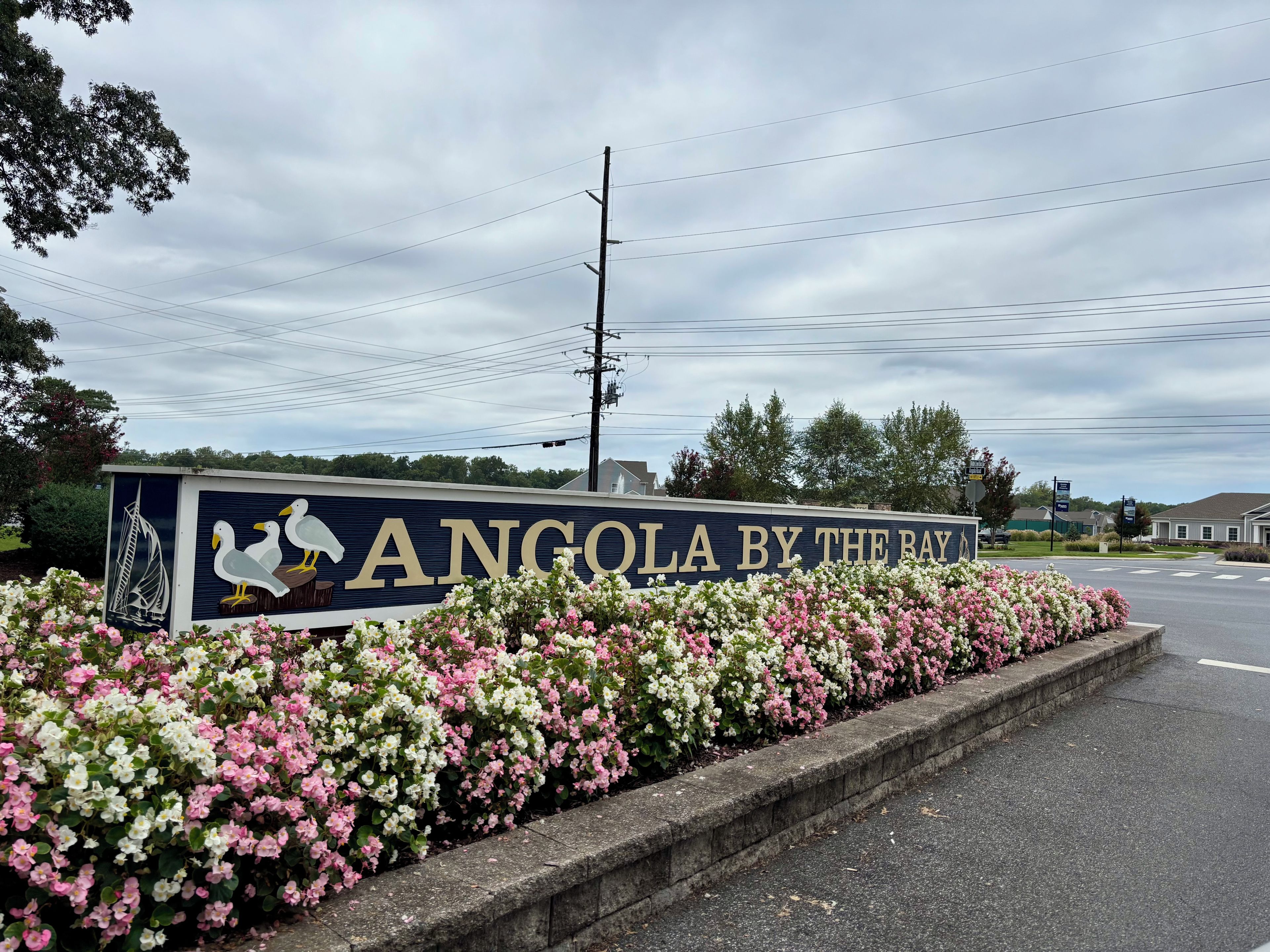 A sign with the text 'ANGOLA BY THE BAY' and a decorative sailboat.