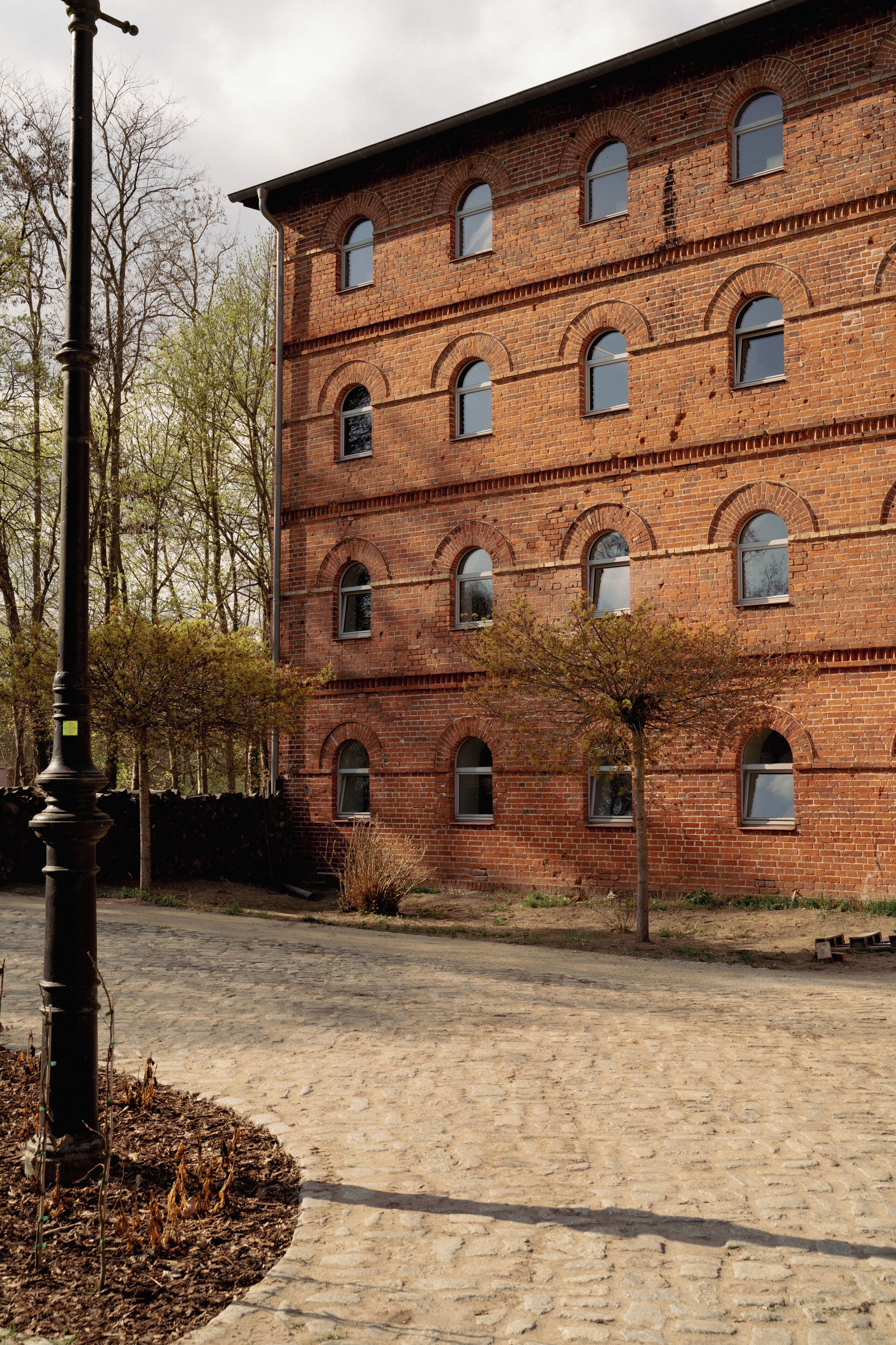 Een meerlaags bakstenen gebouw met gebogen ramen en een geplaveide binnentuin.