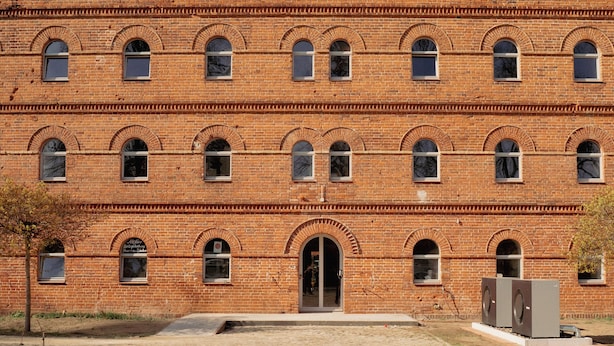A large brick building with multiple windows and a central entrance.