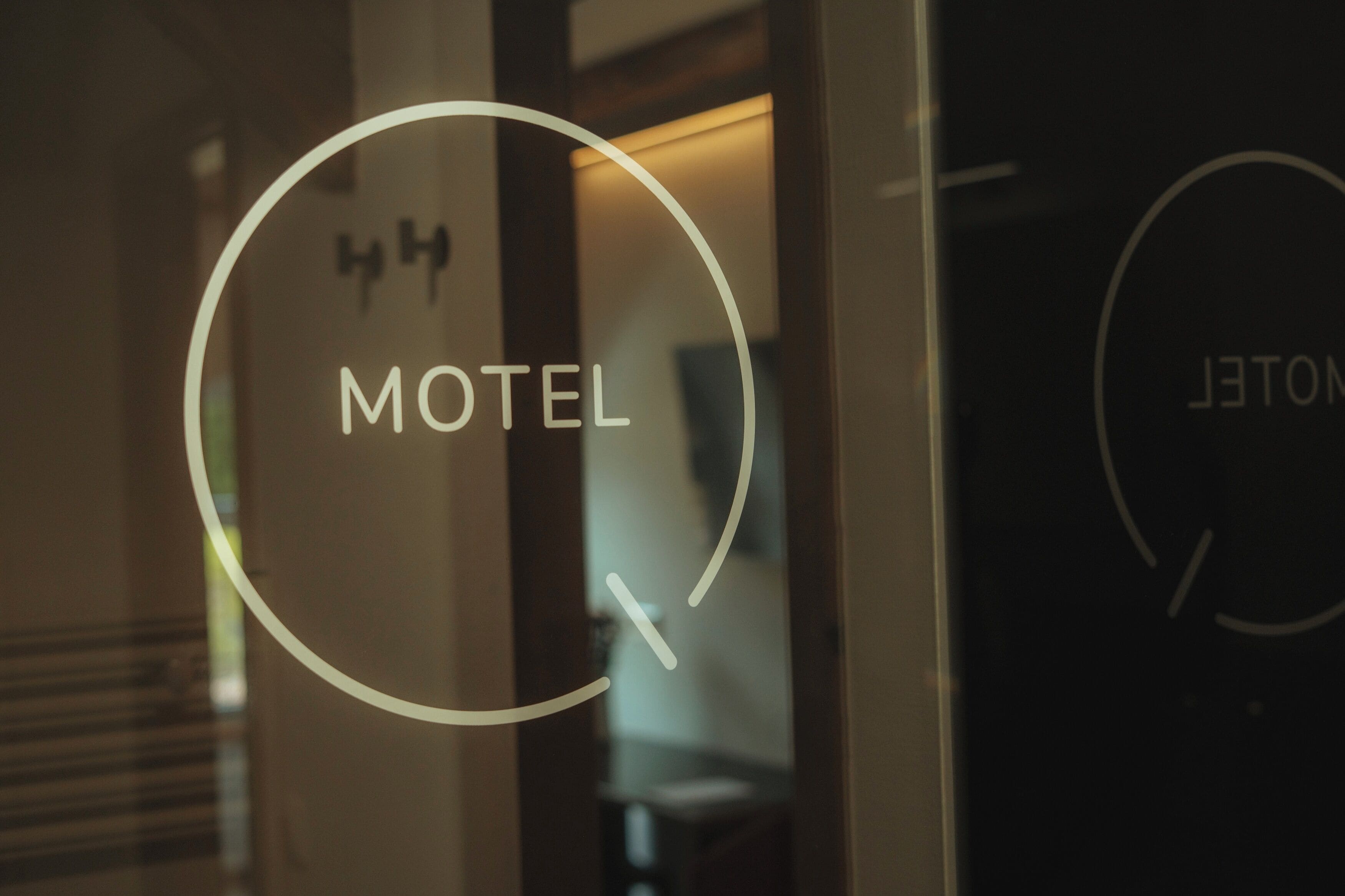 A glass door with the word 'MOTEL' and a circular design element.
