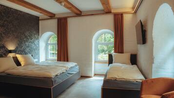 Un dormitorio con dos camas, techo de madera, un ventanal grande y televisor de pared.