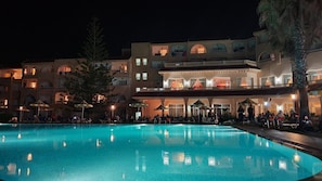 Un hôtel doté d’une piscine, d’un espace extérieur aménagé et de plusieurs balcons.