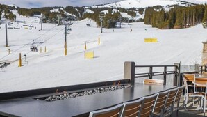 Une station de ski dotée d'un espace de restauration offrant une vue sur une pente enneigée.