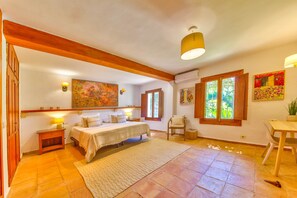 Une chambre à coucher avec un lit, des tables de chevet, un tapis, une fenêtre avec des rideaux et un tableau au mur.