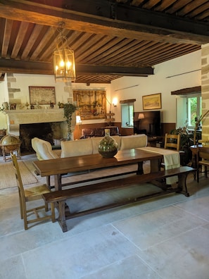 Un salon chaleureux avec une cheminée, des meubles en bois et un mur en pierre.