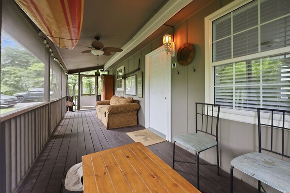 A covered porch with a wooden table and chairs, a ceiling fan, and a view of the outdoors. - Papa Bear Cabin Near Cherokee with Shared Hot Tub (Whittier)