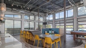 Una cocina moderna con barra, ventanas amplias y vista a la piscina.