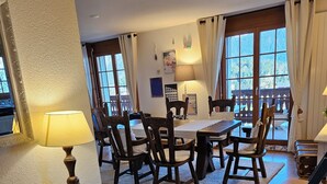 A dining area with wooden chairs, a table, and a lamp. - Spacious central 5-room apartment (Leysin)