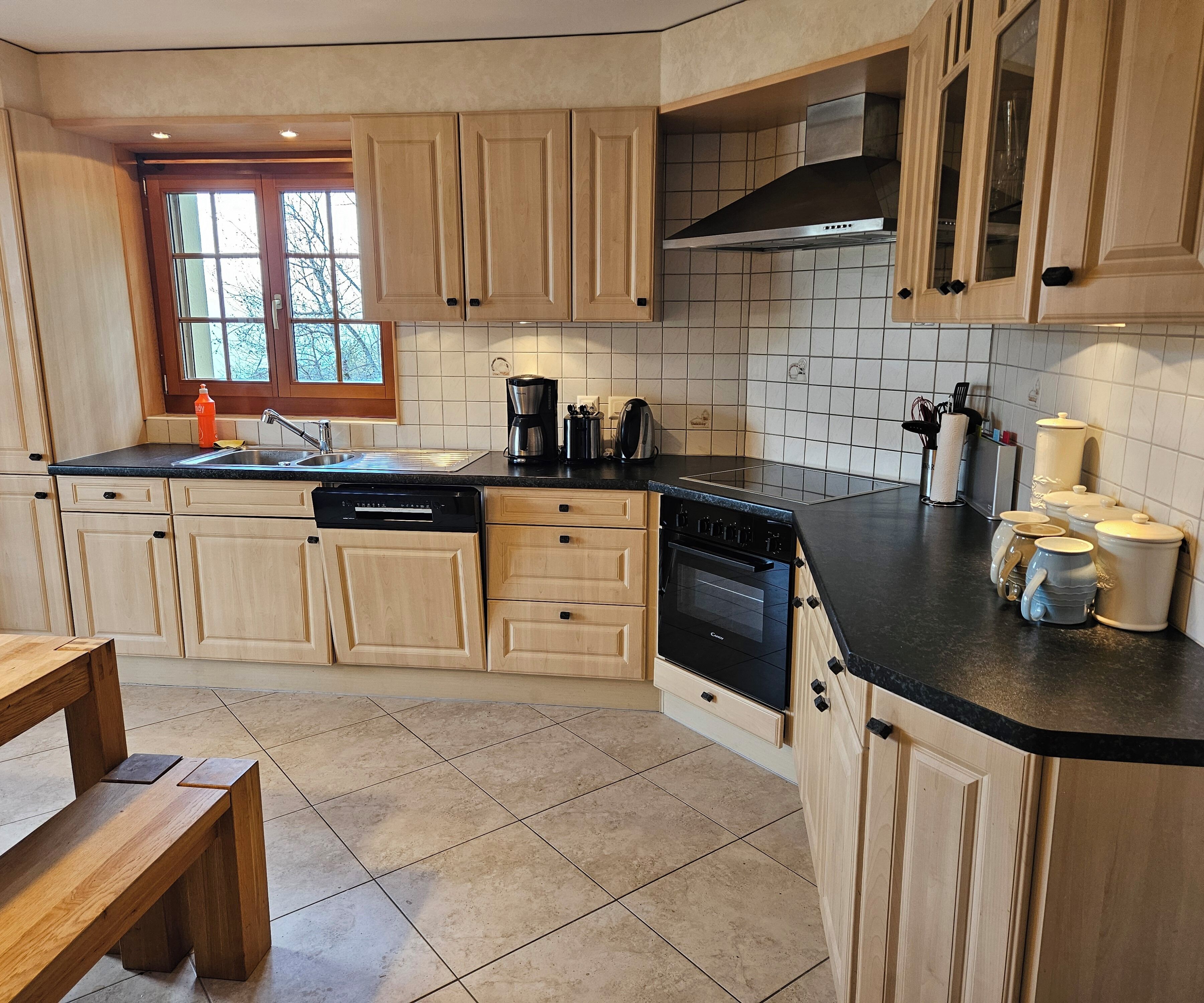 A kitchen with wooden cabinets, a dishwasher, an oven, and a sink.