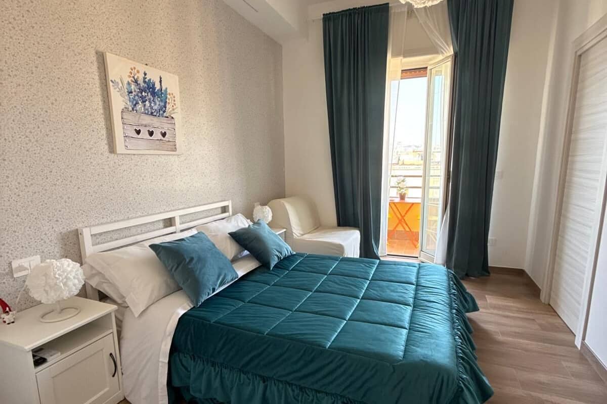 Un dormitorio con cama, mesita de noche y un cuadro en la pared.