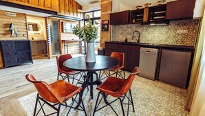 Une cuisine avec une table ronde, des chaises et un vase de fleurs.