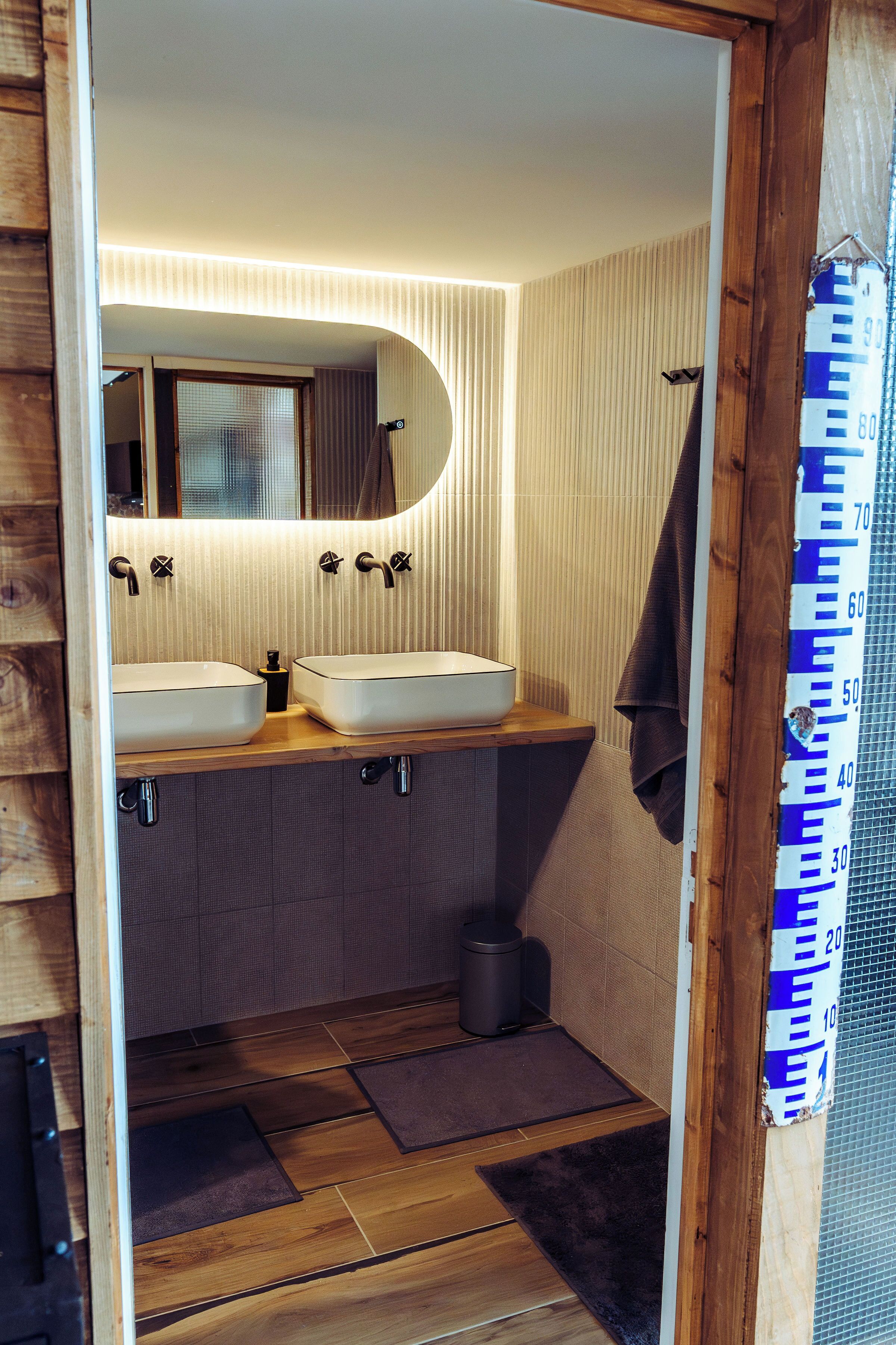 A bathroom with two sinks, a mirror, and a towel rack.