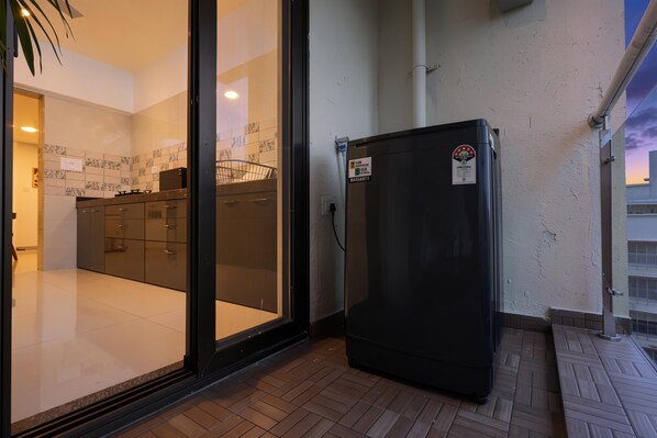 A kitchen with a refrigerator, cabinets, and a tiled backsplash.