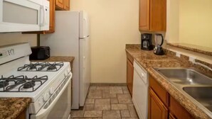 A compact kitchen with a gas stove, microwave, refrigerator, and granite countertops. - Club De Soleil: Usher & Chris Brown R&B Suite! (Las Vegas)