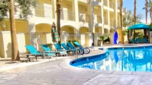 A pool area with lounge chairs and a building with balconies. - Club De Soleil: Usher & Chris Brown R&B Suite! (Las Vegas)