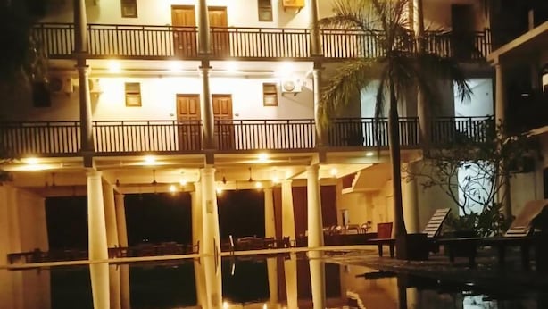 A multi-story building with balconies and a pool reflecting the structure. - Oga Reach Yala (thissamaharama)