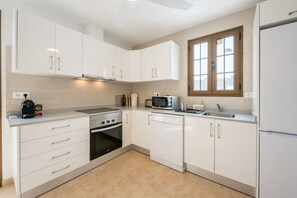 A modern kitchen with white cabinets, a built-in oven, a microwave, and a window above the sink. - Volcanic garden | private pool | 3BR | Family (Yaiza)
