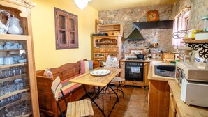 A cozy kitchen with wooden furniture, a dining table, and a built-in oven. - Vacation home  by Interhome (Anatoli)