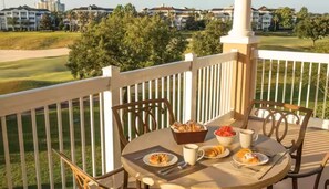 Un balcón con mesa listo para el desayuno, con vista a un campo de golf.