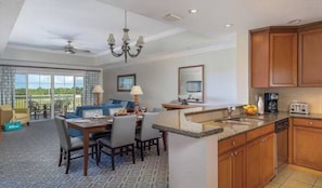 Habitación de hotel con comedor, cocina y balcón con vistas.