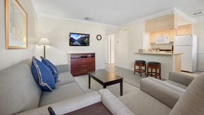 Ein modernes Wohnzimmer mit einer Couch, einem Couchtisch und einem Fernseher an der Wand.