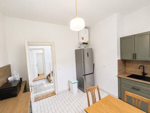 A modern kitchen with a stainless steel refrigerator, a wooden dining table, and a built-in sink. - Villa Plemelj - Apartment Plemelj - sleeps 2 guests  in 1 bedroom (Bled)