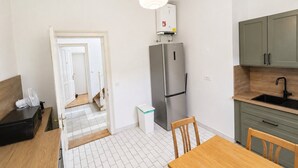 Et moderne køkken med et rustfrit stål køleskab, et træspisebord og en indbygget vask.