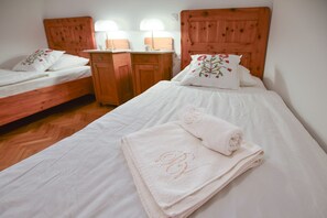 A hotel room with two wooden beds, a wooden nightstand, and a nightstand lamp. - Villa Plemelj - All 4 Apartments - sleeps 8 guests  in 4 bedrooms (Bled)