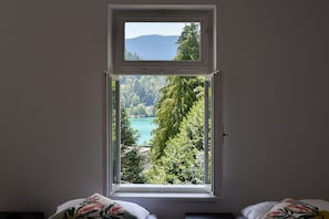 Une pièce avec une fenêtre donnant sur un lac et une forêt.