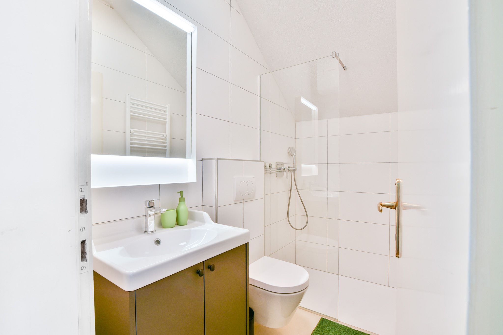 Une salle de bain avec un lavabo blanc, des toilettes et une douche.