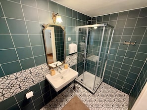 A bathroom with a shower, sink, and mirror.