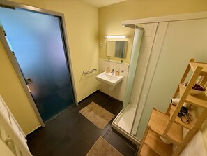Ein Badezimmer mit Waschbecken, Spiegel und Dusche.