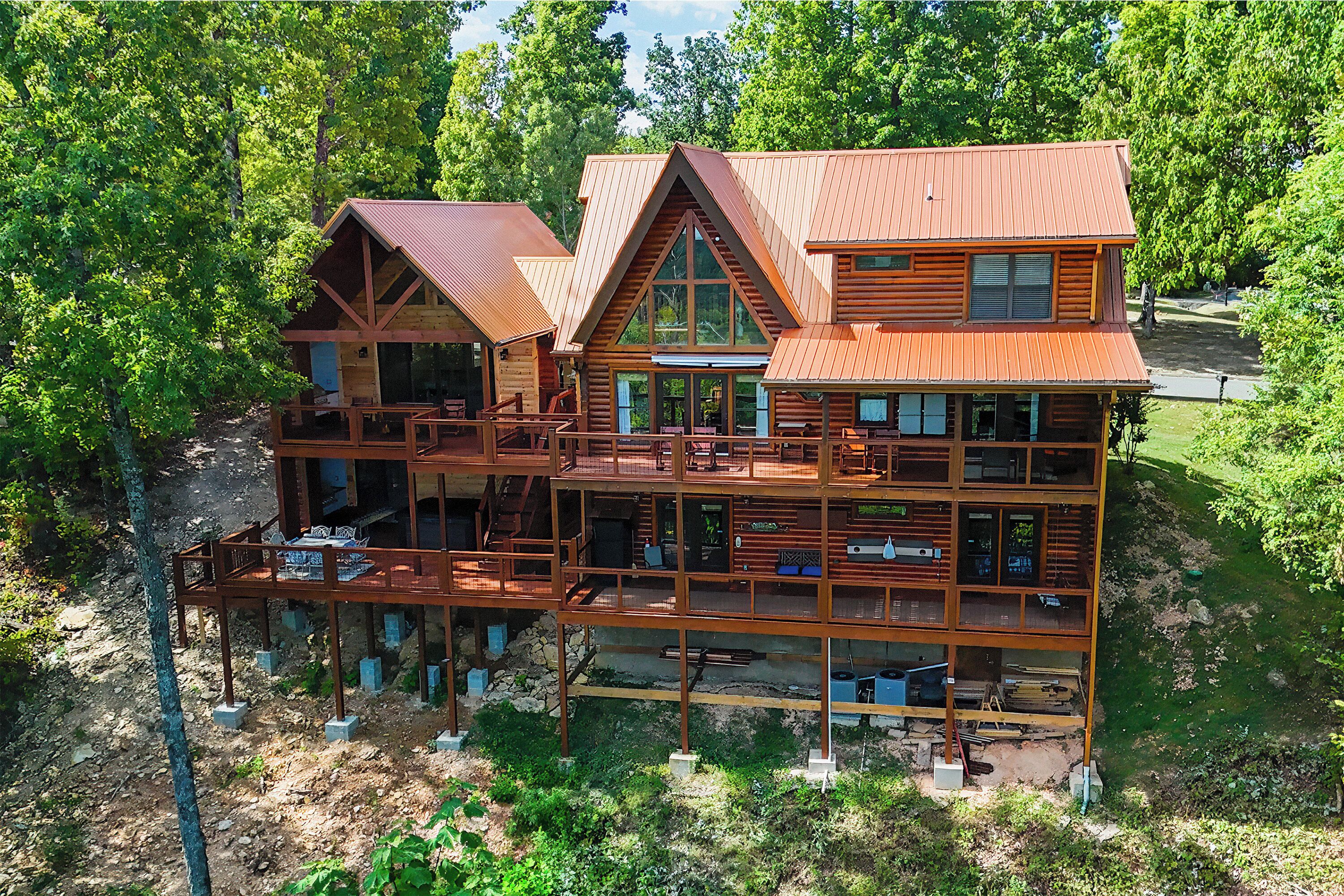 A multi-story log cabin with a deck and multiple rooms.
