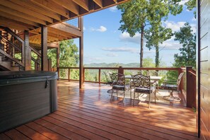 A wooden deck with a hot tub, outdoor seating, and a scenic mountain view. - Psalm 27 05 Relaxing Smoky Mountain Cabin | 3 Bedrooms, 4 Baths, Sleeps 10 (Sevierville)
