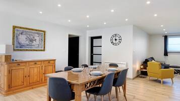 Een eetgedeelte met een houten tafel voor vier personen, omringd door stoelen.