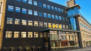 Un bâtiment moderne, reconnaissable à son grand panneau « VIVE », à ses larges fenêtres et à son entrée en verre.