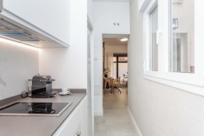 A modern kitchen with a coffee machine, a countertop, and a window. - A spacious furnished studio in the heart of Tetuán with its own private patio, for slow coffee in the morning or a workday in the sun. (MADRID)